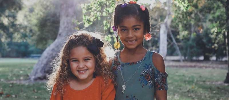 Two young girls who are friends, smiling.