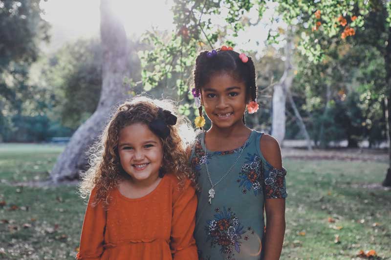 Two young girls who are friends, smiling.