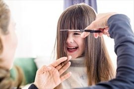 Child laughing while getting her haircut.