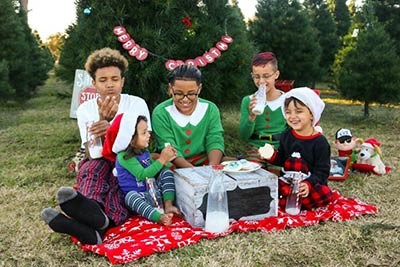 Children eating outside in holiday outfits.