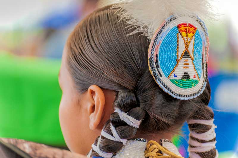 Native American girl facing away from the photo.