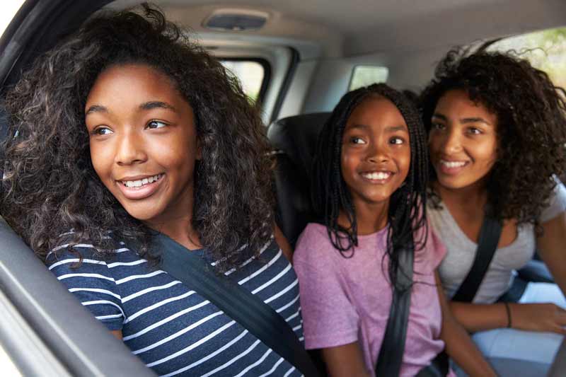 Family smiling in car.