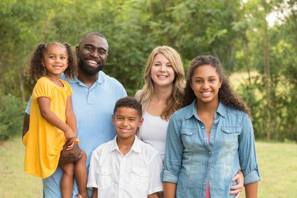 Happy family outside smiling.