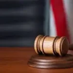 Gavel on a judge's bench with American flag in the background