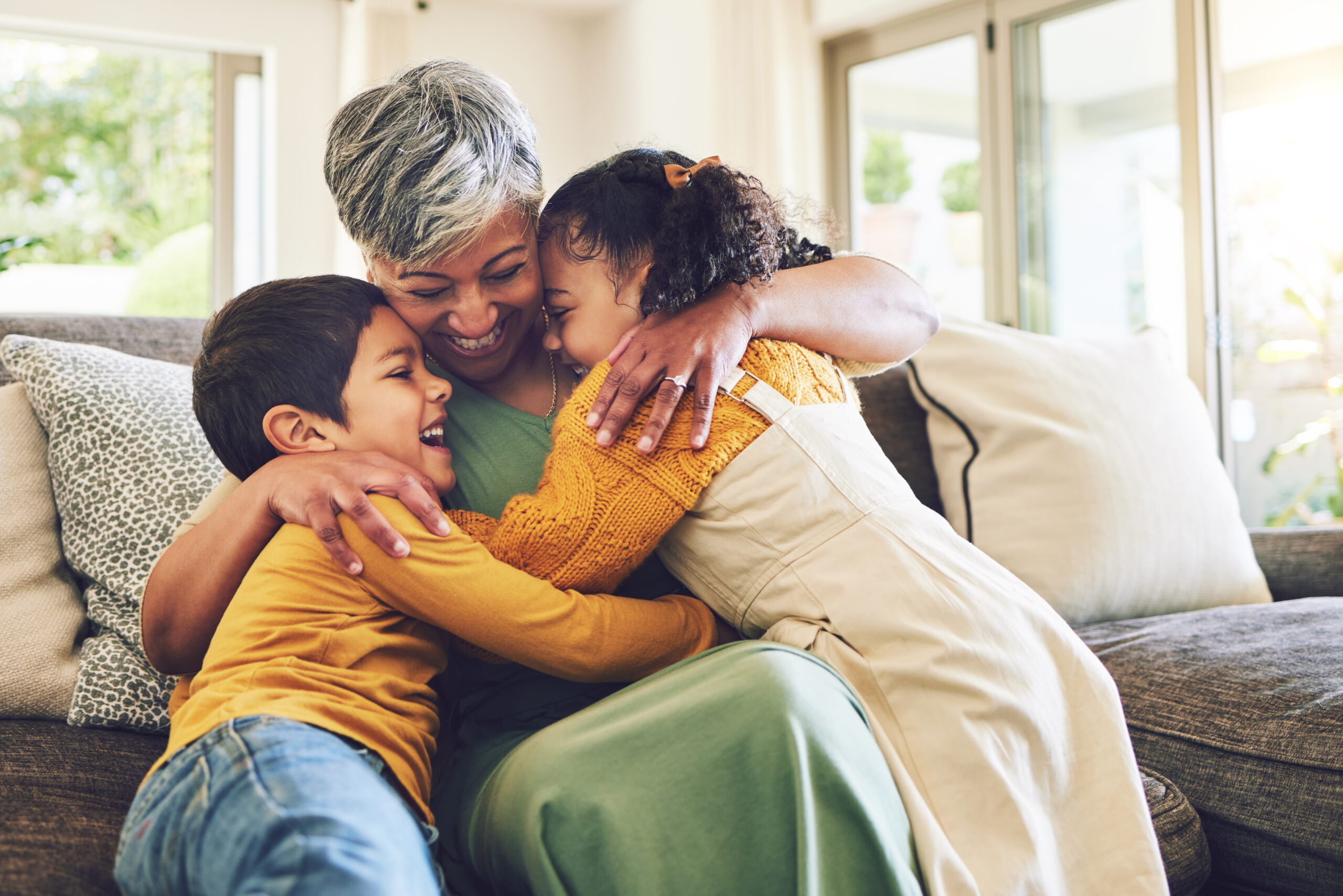 Grandmother embracing two children on a couch