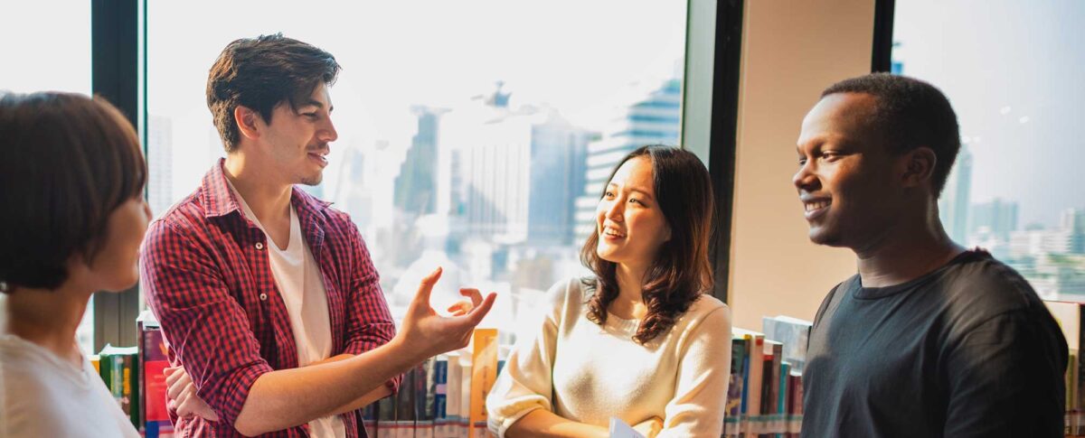 Group of young adults talking in a library