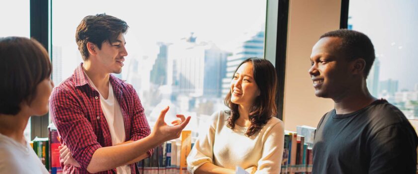 Group of young adults talking in a library